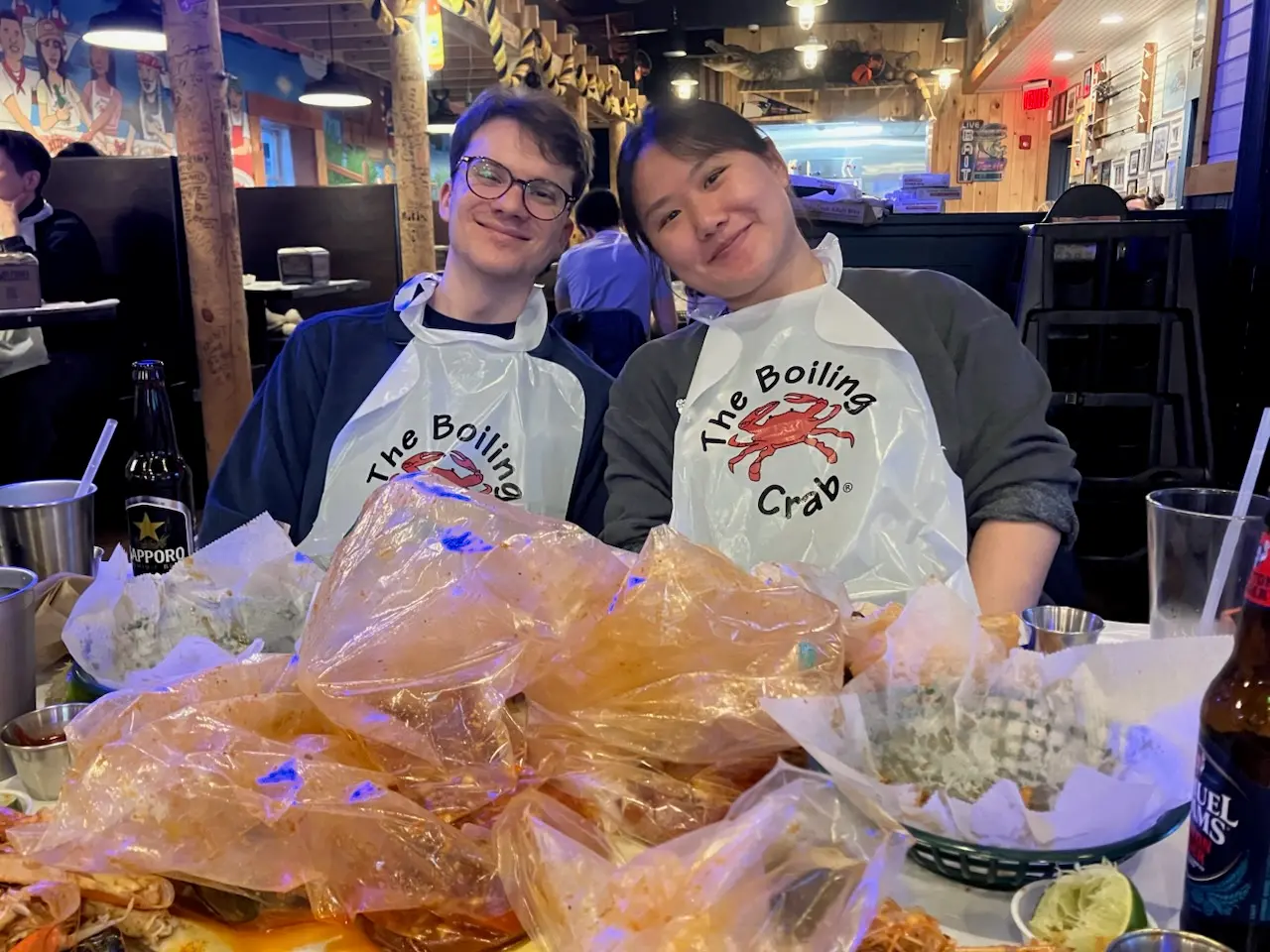 Angela and Sean wearing bibs at a seafood boil
