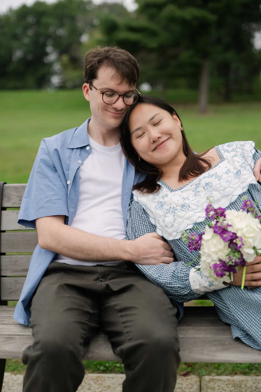 Angela and Sean sitting close together on a park bench