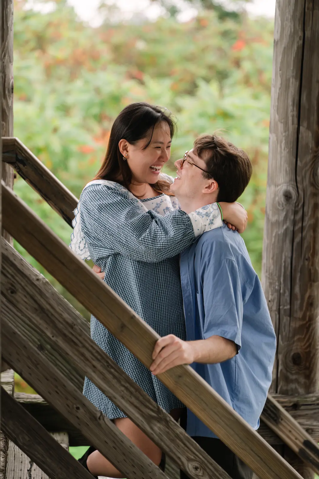 Angela and Sean laughing together on a wooden staircase